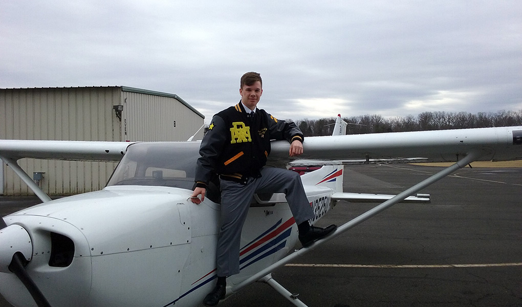 Jacob Gehly poses with the R-MA plane after completing his first solo flight. Photo by Ryan Koch.