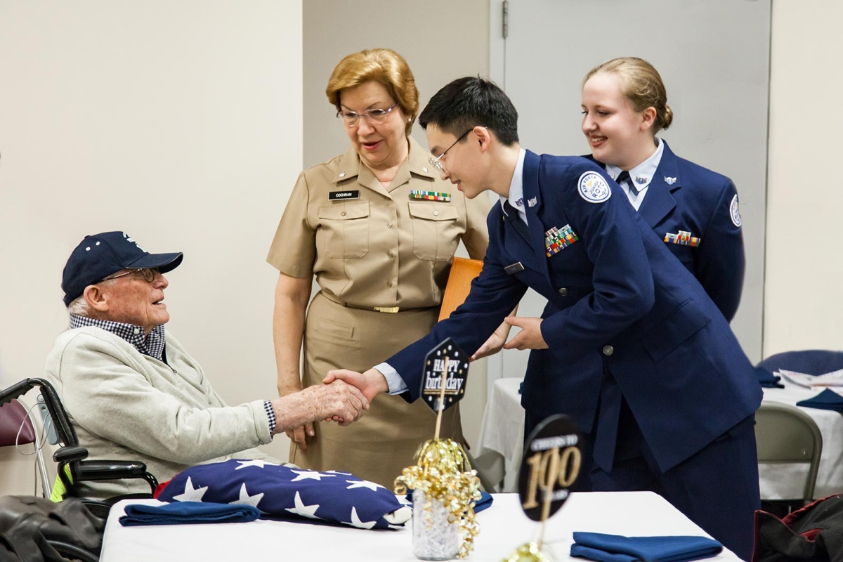 R-MA cadet Ethan Park '22, on right, shakes hands with SMSgt William Griffith, USAF, Retired, and wishes him a happy 100th birthday.