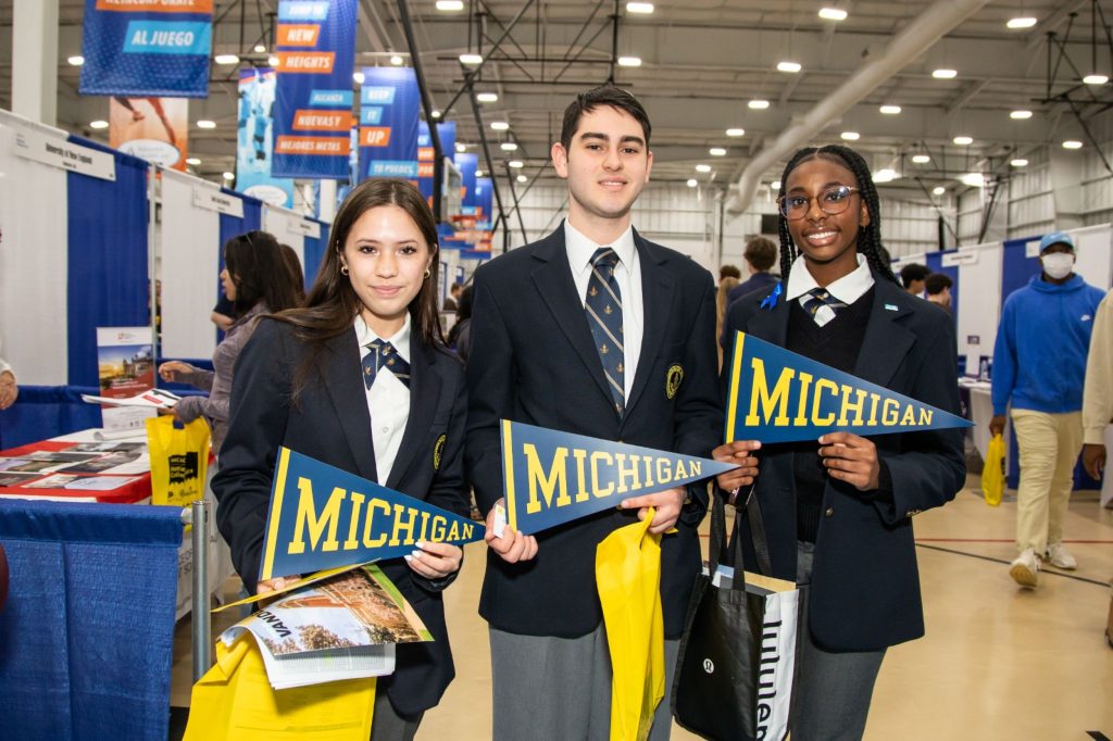 R-MA students holding college paraphernalia at one of our annual college fairs