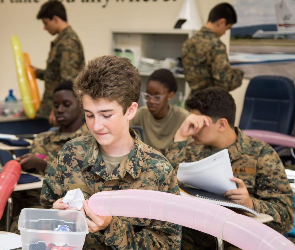 A private school student completing an aviation activity at his desk