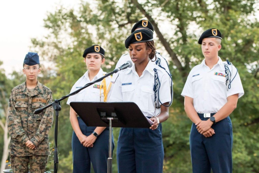 A private school student in uniform speaking on the podium.