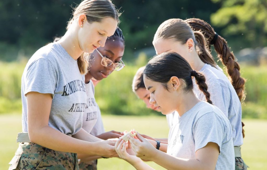 A pair of cadet leadership students collaborating on a team activity outside