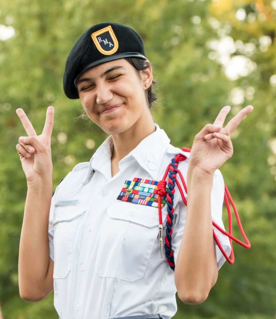 A preparatory school student posing and making a peace sign with both hands