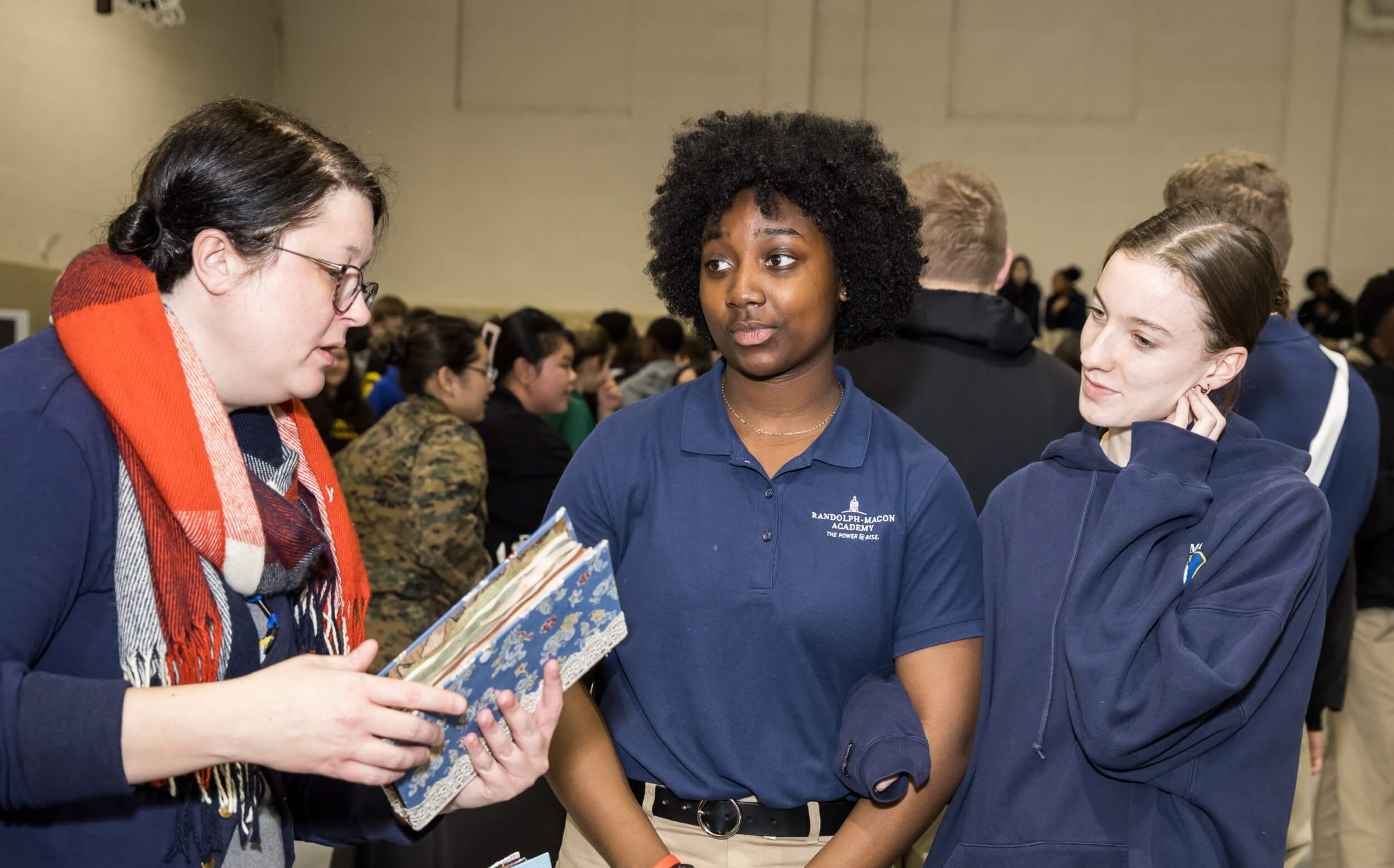 Two female students interacting with a college representative at our college prep school