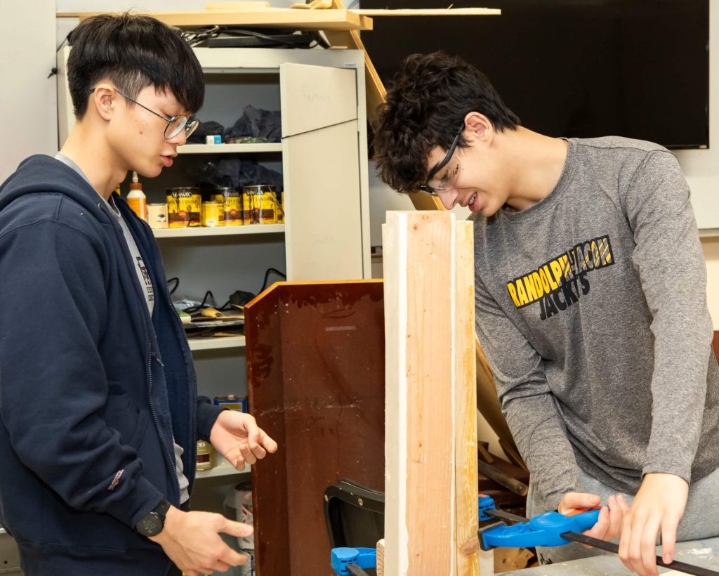 A pair of male students working with wood in shop class at our private school