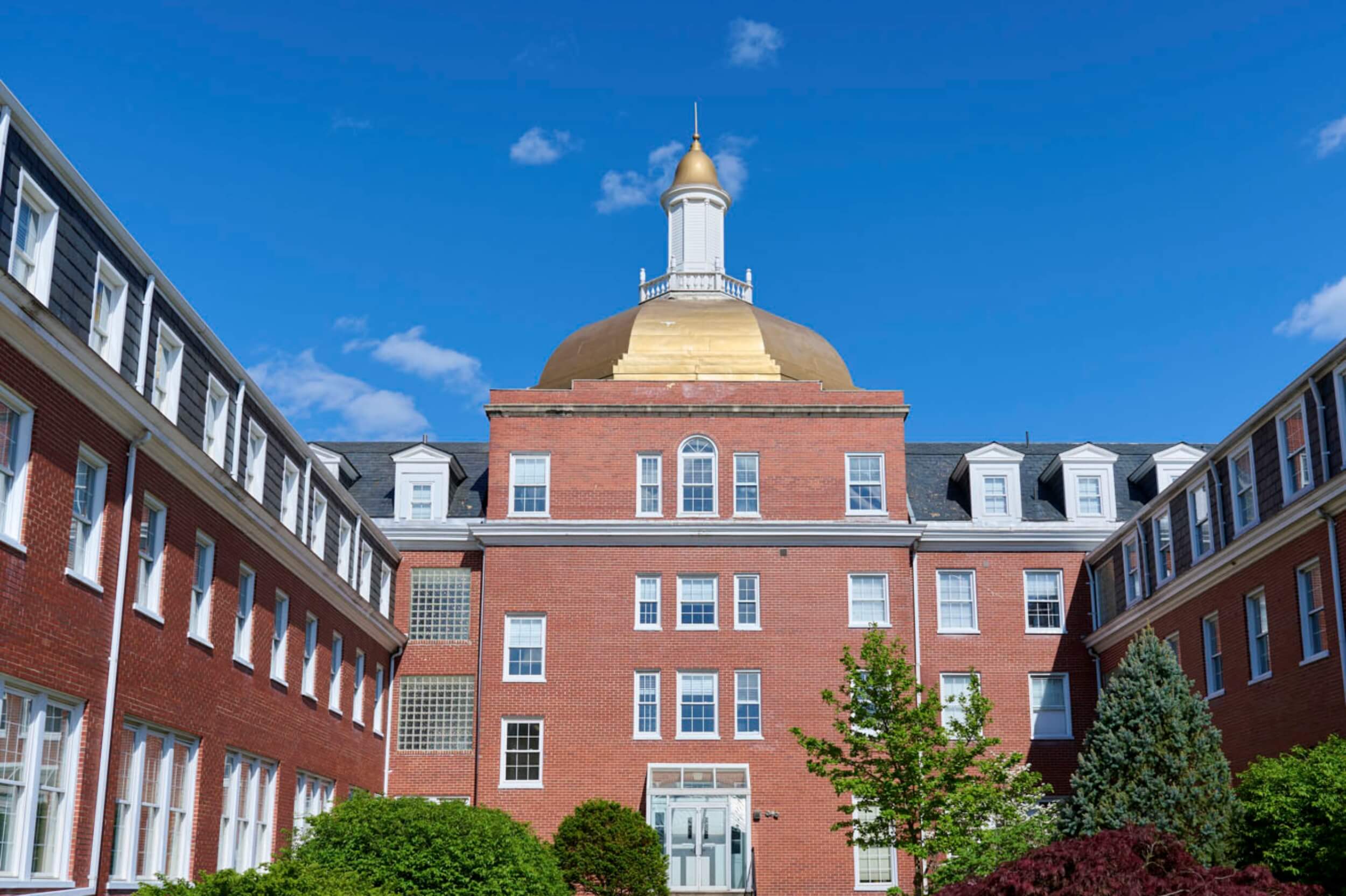 A historic red-brick building with a gold dome on the R-MA campus, representing a distinguished 8th-grade boarding school in Virginia.