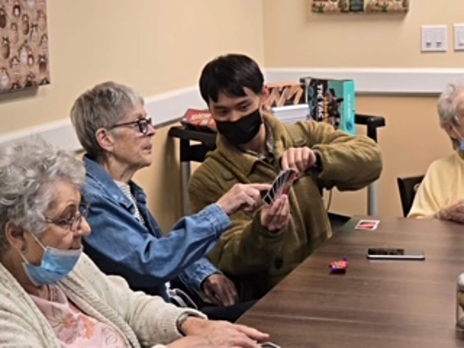 A cadet interacting with senior citizens at a care home during a community service initiative