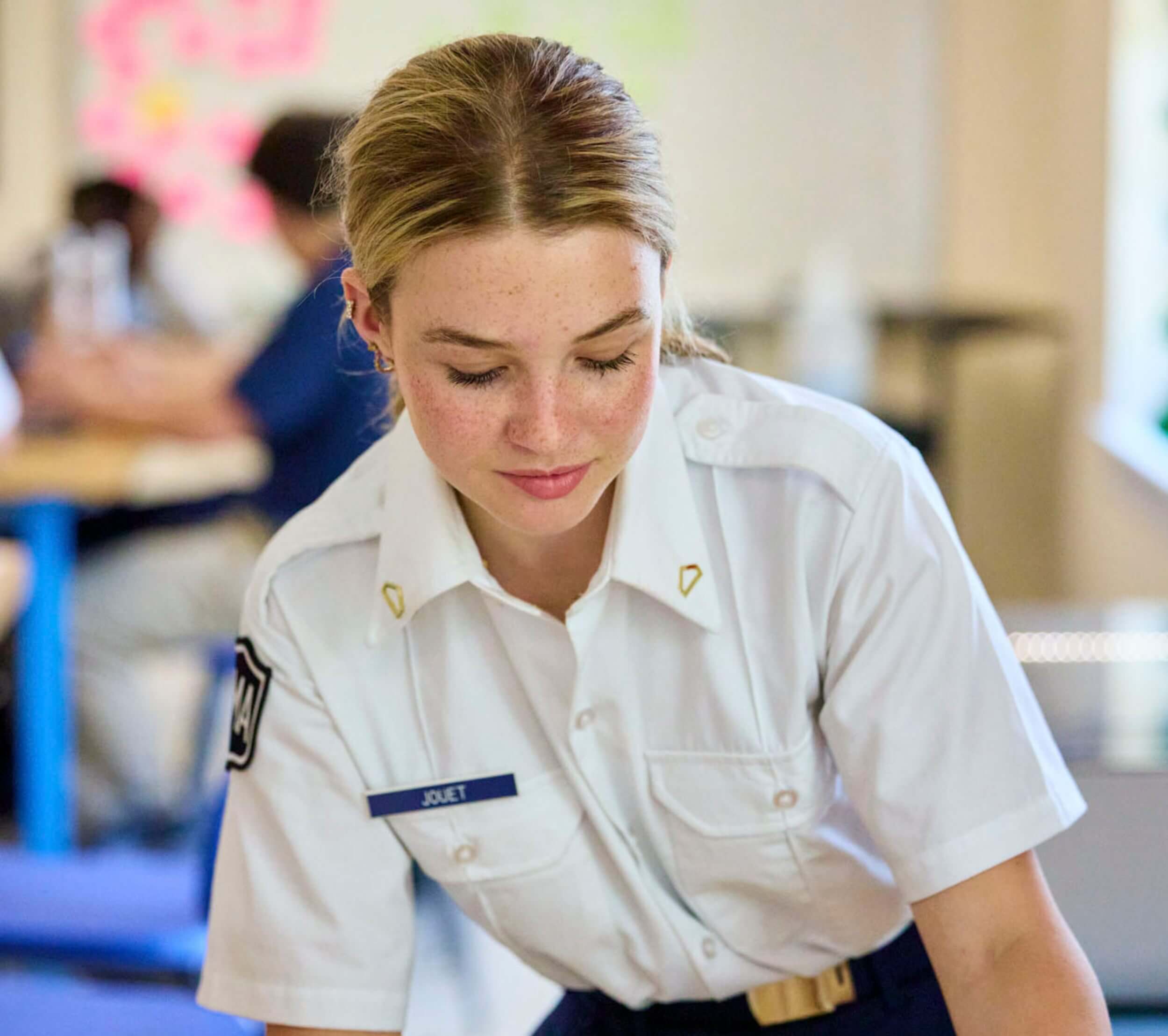 A female cadet at our preparatory school in Virginia assembling mechanical parts in a Robotics class
