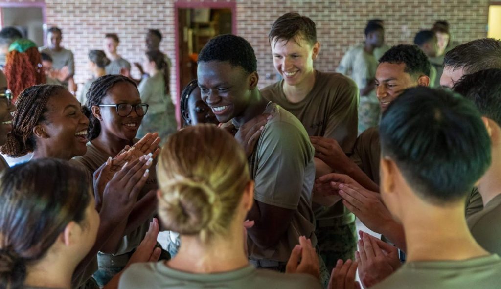 A group of students celebrating together during a team-building activity that reflects modern military concepts and leadership development at R-MA