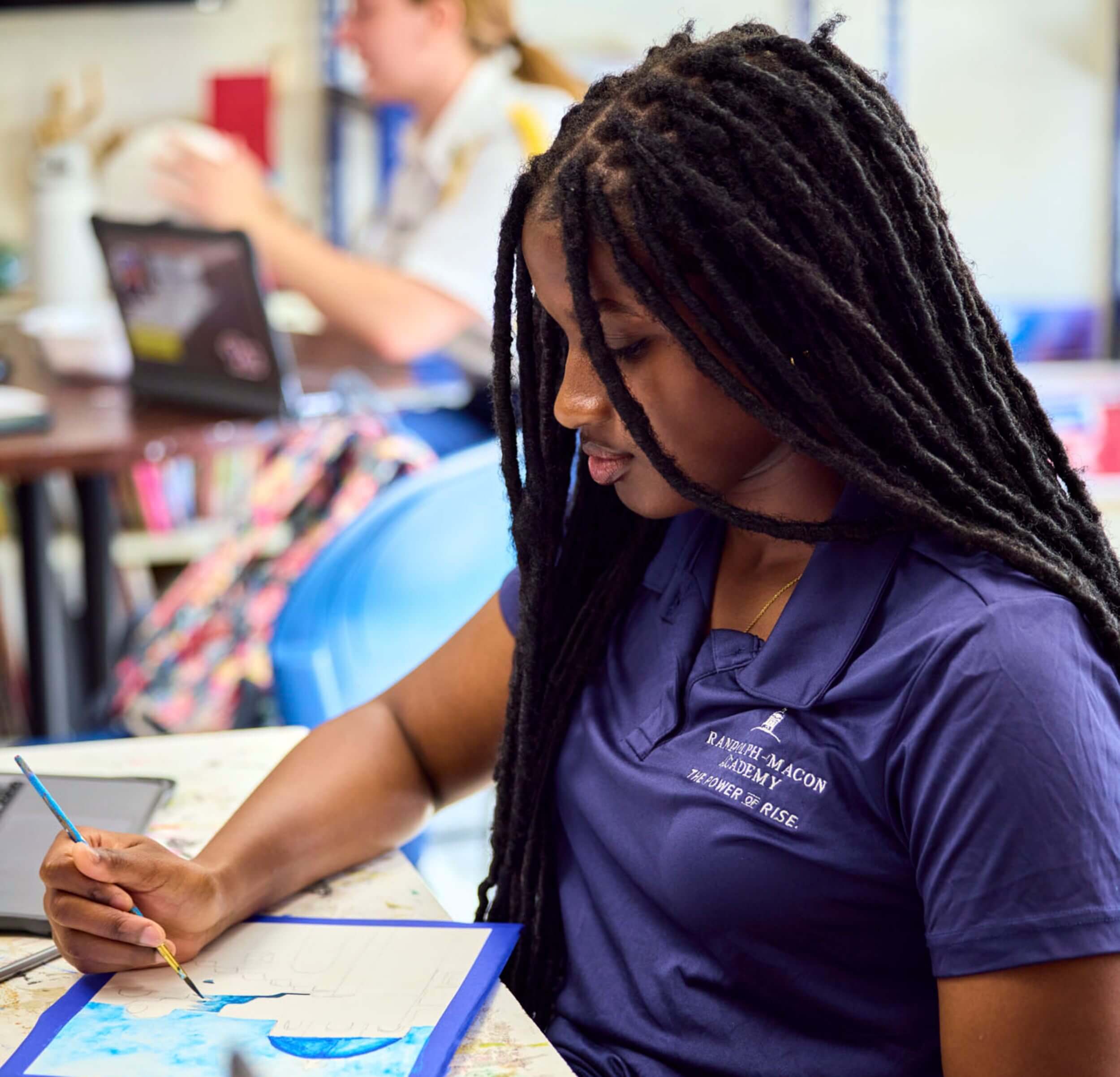 A female student painting in a visual and performing arts class at a performing arts boarding school
