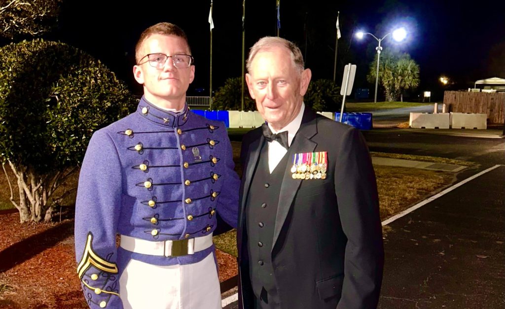R-MA student standing with his grandfather, a former student, representing the long-term impact of small class sizes in high school on confidence and personal growth