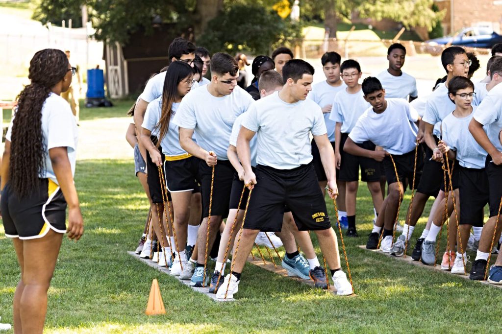 A team of R-MA students participating in an outdoor teamwork activity, showing character education for high school students through collaboration and leadership