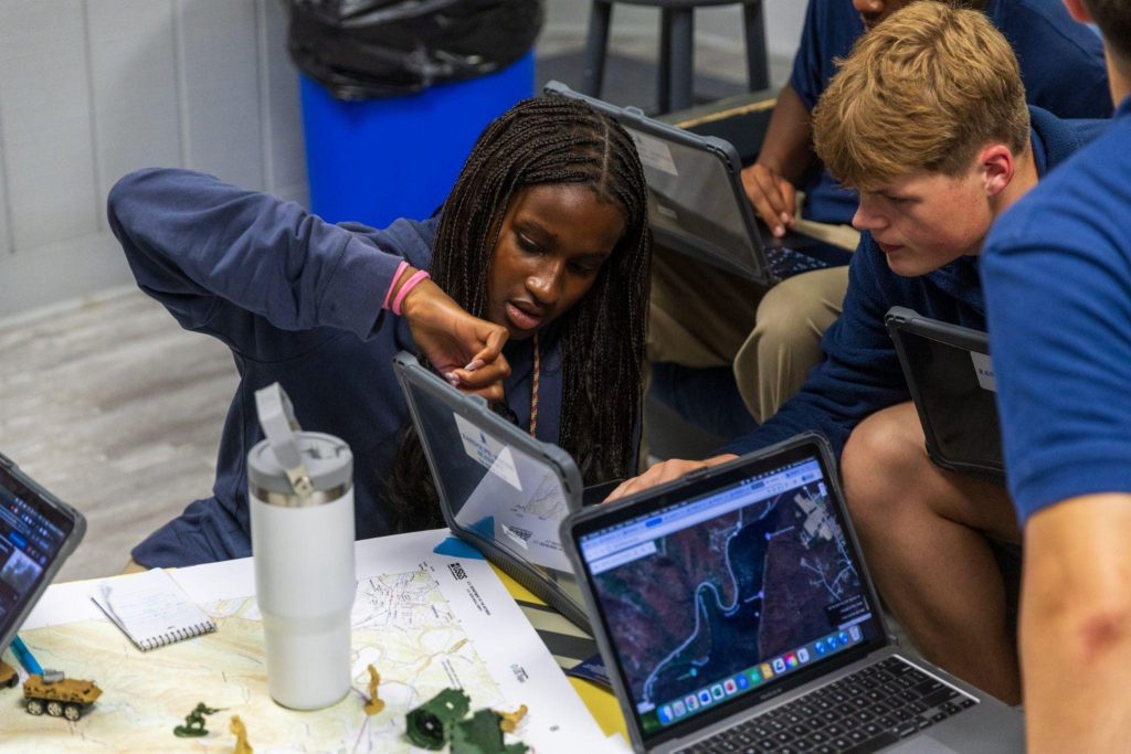 A pair of students working together during a cybersecurity camp for teens, developing problem-solving skills and learning data protection and networking basics