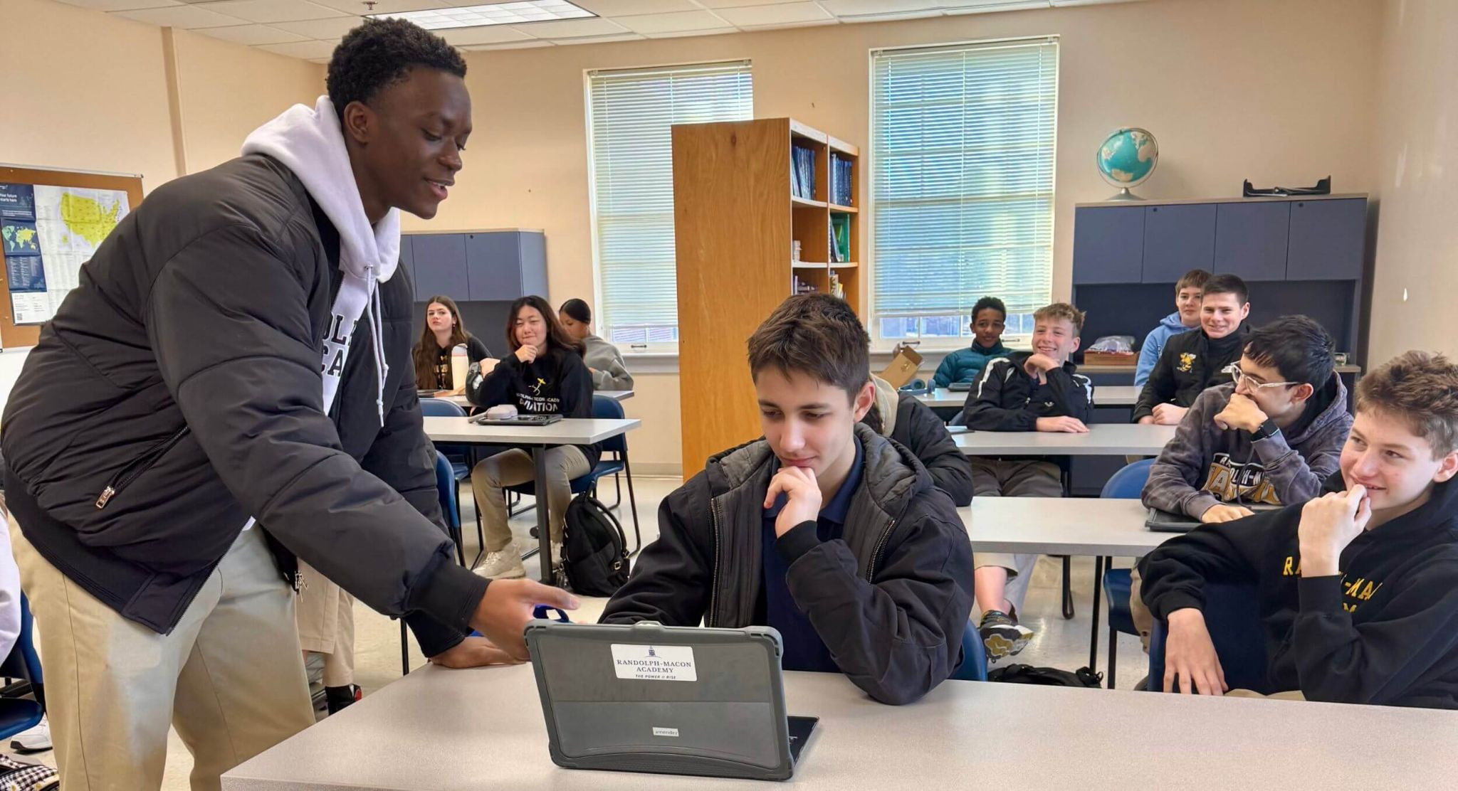 A class of students participating in a cybersecurity summer program for high school students, working on laptops to analyze data and solve technical challenges