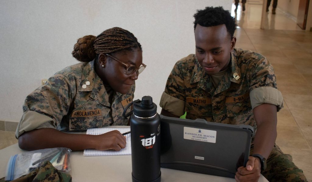 Two R-MA students working together on a tablet, showing mentorship for high school students and academic accountability