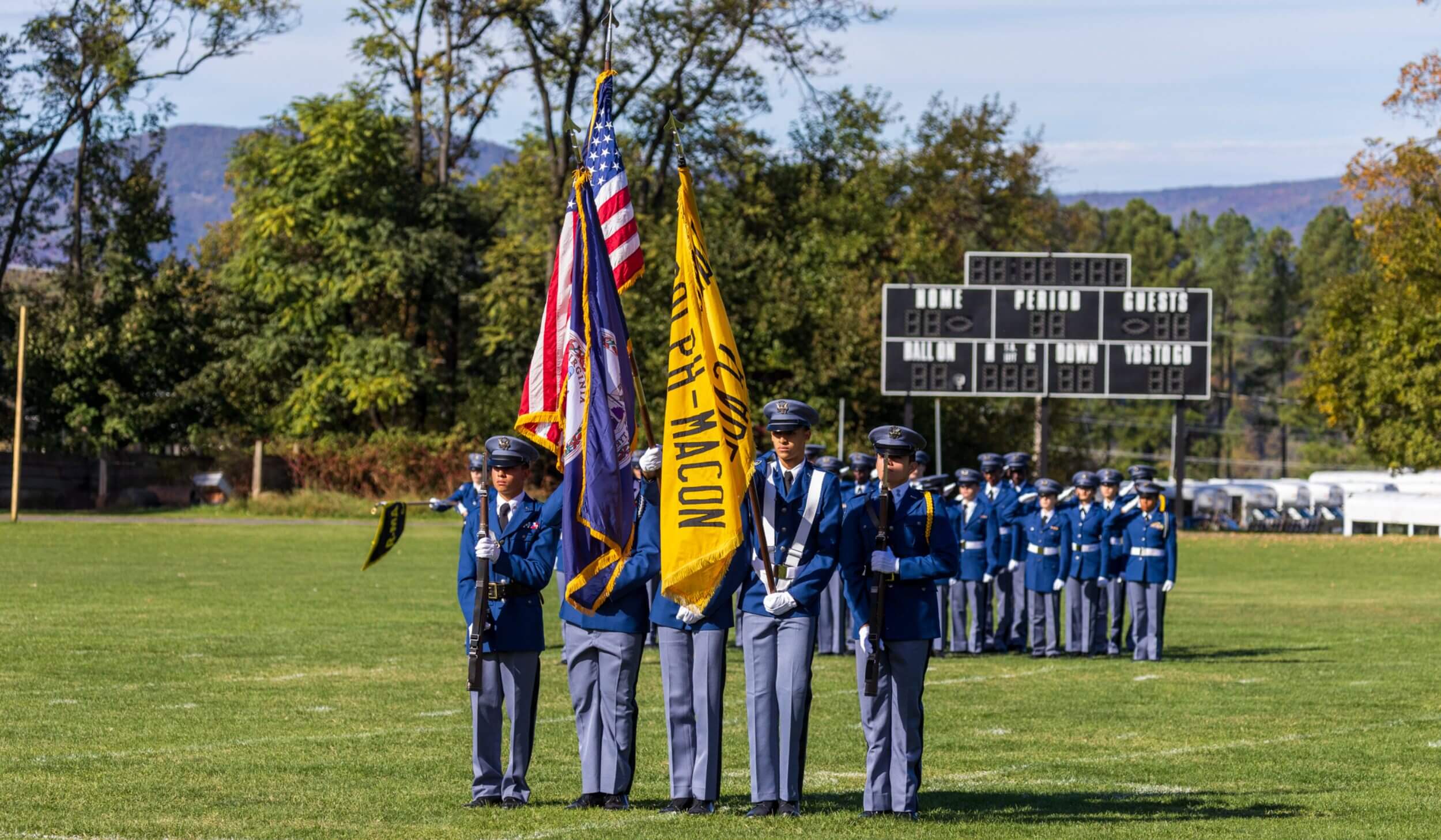 A group of R-MA cadets standing in formation with flags, reflecting leadership, structure, and student belonging through mentorship