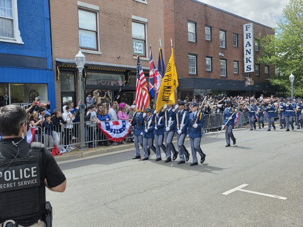 Randolph-Macon Academy cadets and marching band performing in a parade through Front Royal during the royal visit celebration.