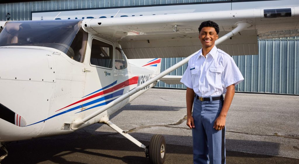 An aviation program student stands beside a training aircraft during flight instruction at Randolph-Macon Academy's high school aviation program.