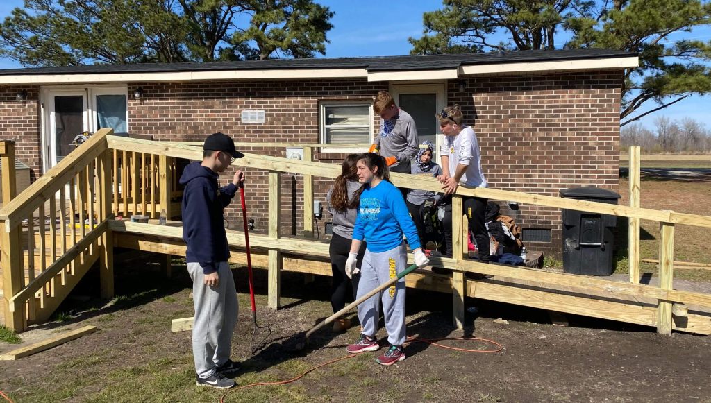 R-MA student participating in a community service construction project that develops leadership skills and prepares students for careers in public service.