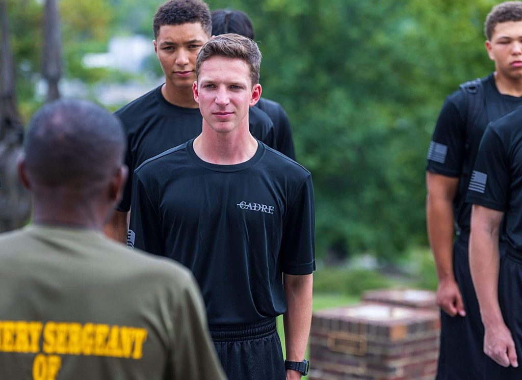 A group of Randolph-Macon Academy cadets listening during an outdoor leadership activity, developing communication, focus, and confidence within the school community.