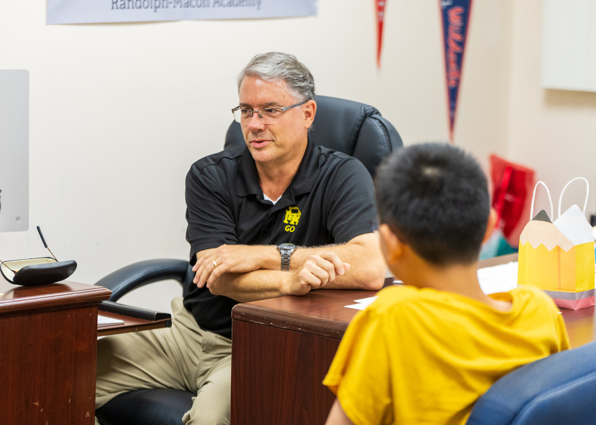 An R-MA teacher providing personalized academic guidance to students during a classroom lesson at Randolph-Macon Academy.