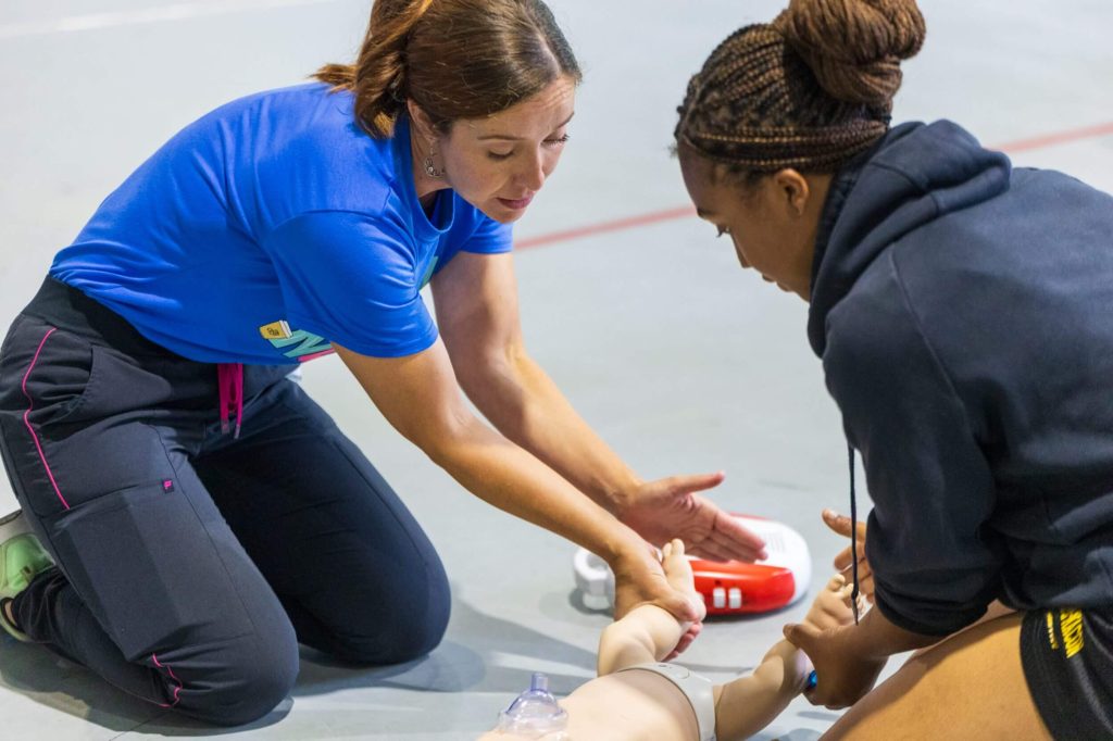 An R-MA student practicing CPR and emergency-response skills with an instructor during hands-on training.